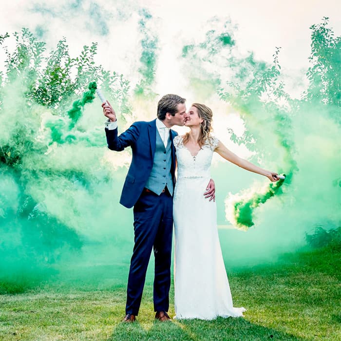 Pareja en una celebración acompañada de humo de color